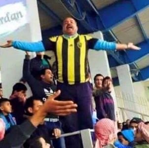 In this photo shared on social media networks, Faisali fan Mazen Beni cheers for his club during a football match against Ahli on Saturday wearing the jersey of Saudi Arabia's Ittihad